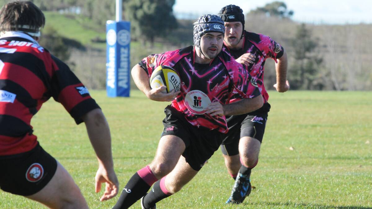 PRETTY IN PINK: CSU Orange star Sam O'Leary takes the ball forward in his side's pink jersey, raising money for the McGrath Foundation. Photo: JUDE KEOGH 0523aggies3