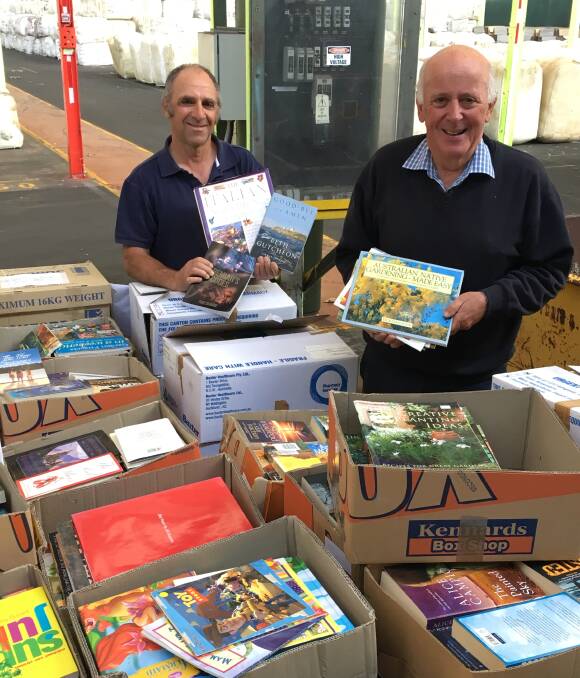 BOOK FAIR: Lifeline volunteer Bill Miller and executive officer Alex Ferguson with some of the 22,000 books for sale in the upcoming Spring Book Fair. Photo: NADINE MORTON 102016nmbooks6