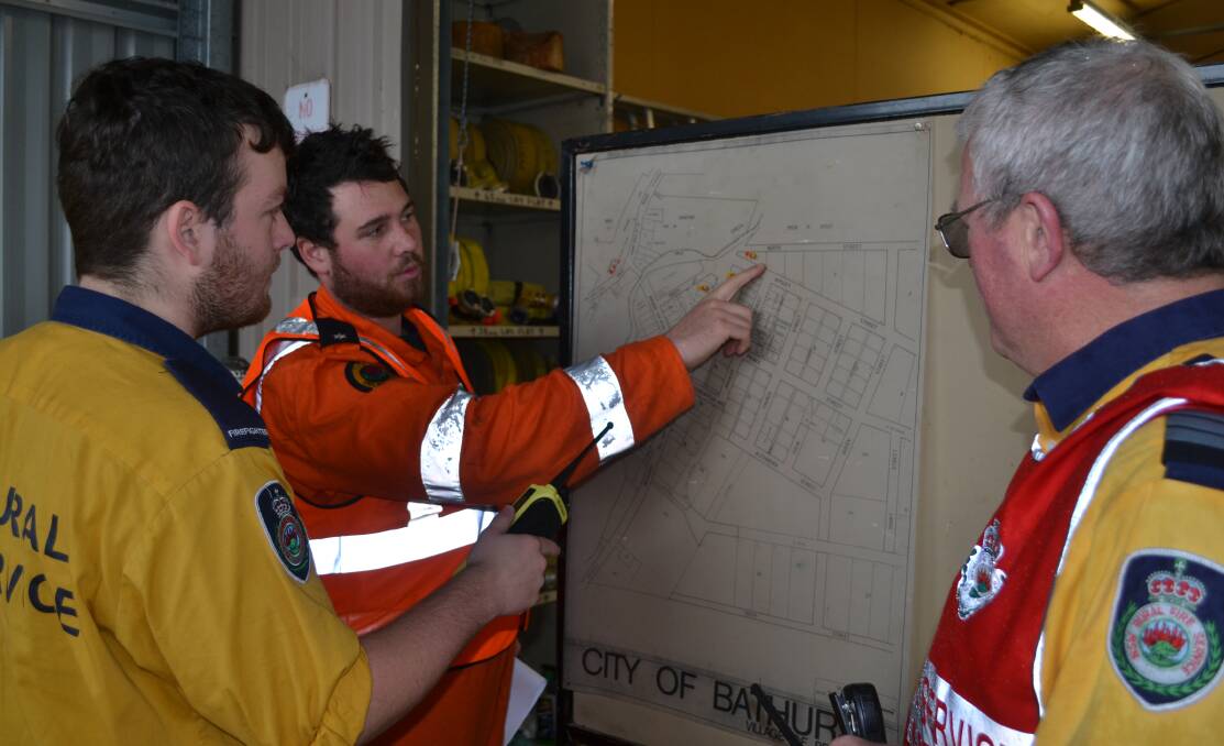 PLANNING: SES' Charles Milne (centre) planning crew responses with Rural Fire Services' Thomas Norman and Col Humphries. Photos: NADINE MORTON 072016nmflood