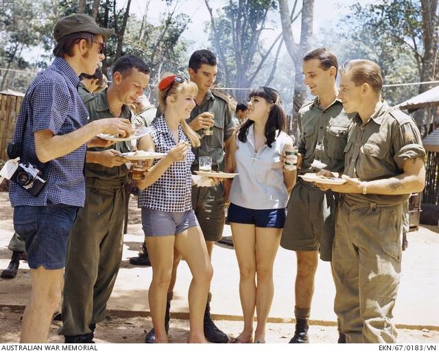 Bruce Irvine (second from left) with performers Patti McGrath and Denise Drysdale in Nui Dat, Vietnam. Photo: AUSTRALIAN WAR MEMORIAL