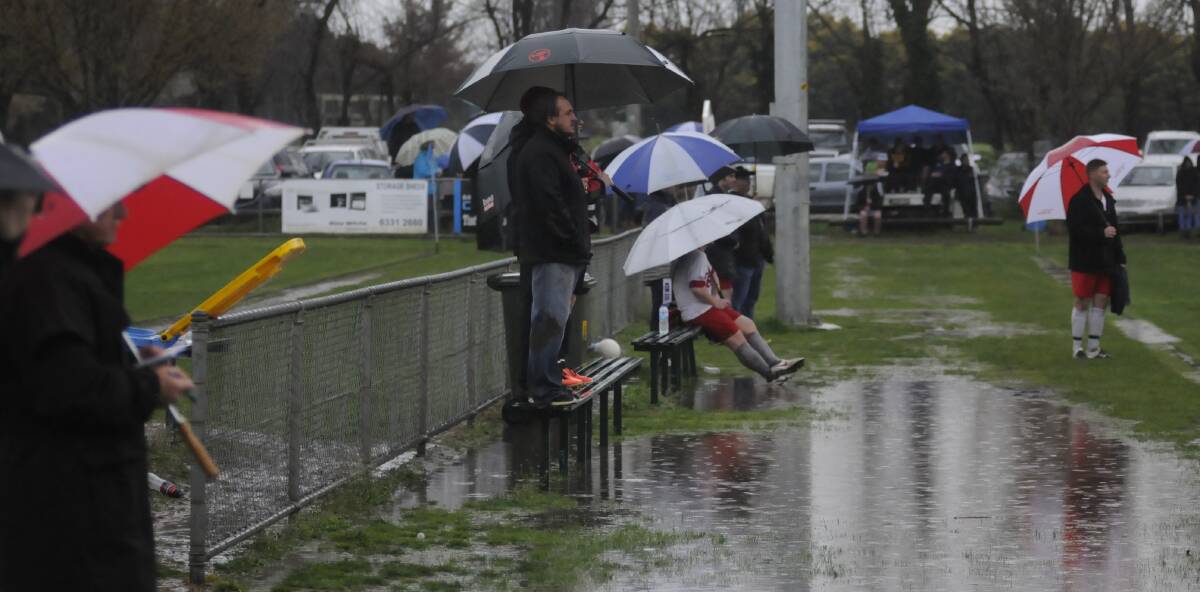 SNAPSHOT: Dedicated soccer fans sought refuge from the rain during a grand final at Proctor Park on Sunday. Photo: CHRIS SEABROOK 091816csnap