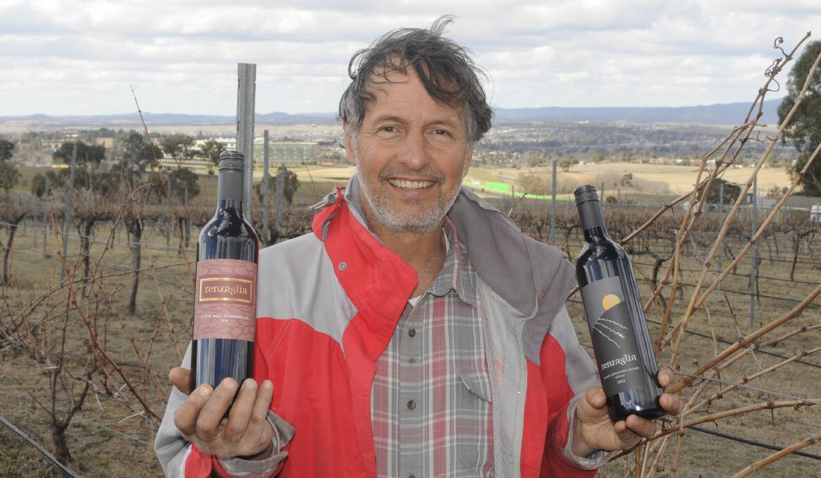 UP FOR JUDGING: Bathurst vigneron Mark Renzaglia with two of the seven bottles he has entered for judging in the National Cool Climate Wine Show. Photo: CHRIS SEABROOK 090417cwines1