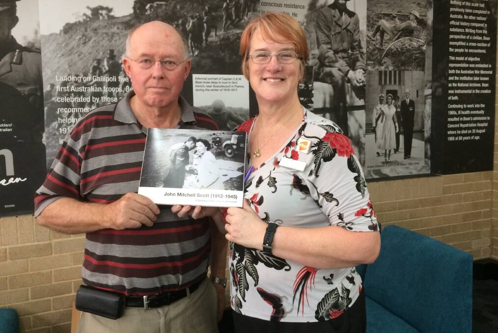 WAR HISTORY: Bill Kierath presents his book on John Mitchell Scott who died during World War II to Bathurst Library information and lending services team leader Beth Hall. Photo: SUPPLIED 030518book