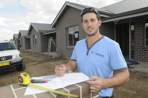 COME TOGETHER: Nathan Baldi of Get Hammered Building at work on the luxury villas at 190 Gilmour Street. Bathurst Regional Council’s aim is to eventually have 25 per cent of residents living in some form of medium density housing. Photo: CHRIS SEABROOK	 031212cdwellng1