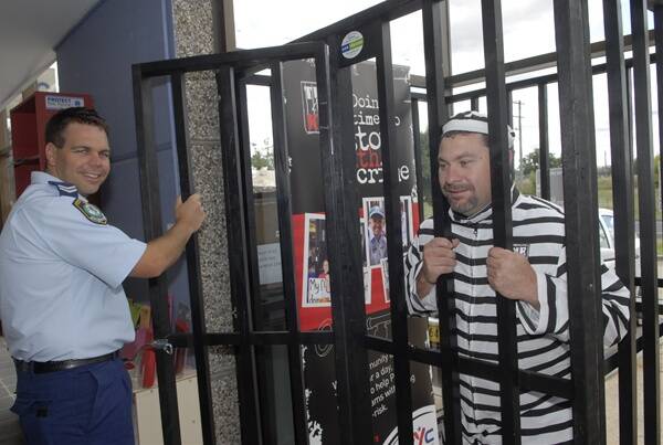 THROW AWAY THE KEY: Senior Constable Scott Bowden throws Bathurst PCYC manager Matt Brealey into the lockup so he can get a feel for what our community leaders will go through next month. Photo: PHILL MURRAY 030811ppcyc