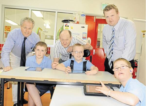 HIGH TECH TABLETS: Carenne School principal Neil Moon, Rotary Club of East Bathurst president Terry Mahony and community service director Daniel Sharpe look on as Carenne School students Isaac Callan, Mitchell Allan and Mitchell Smith use iPads. Photo: CHRIS SEABROOK 103111carenne2