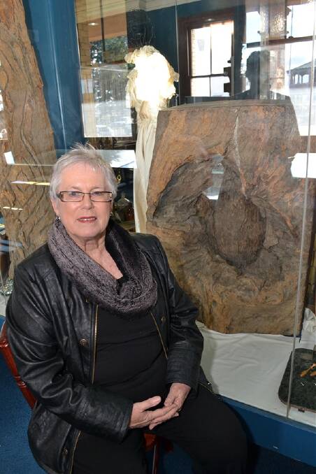 CELEBRATING OUR HISTORY: Councillor Monica Morse sits by the tree trunk carved by explorer George William Evans when he discovered the Bathurst Plains in 1813. The trunk is on display at the Bathurst District Historical Society Museum. Photo: PHILL MURRAY	 060712pmonica