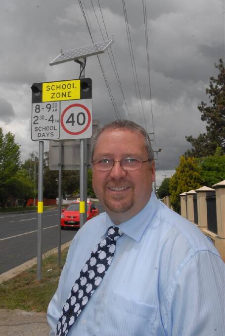 SAFETY FIRST: Kelso Public principal Lance Cooper with the new flashing lights outside his school on busy Gilmour Street. Photo: PHILL MURRAY  102511plites2