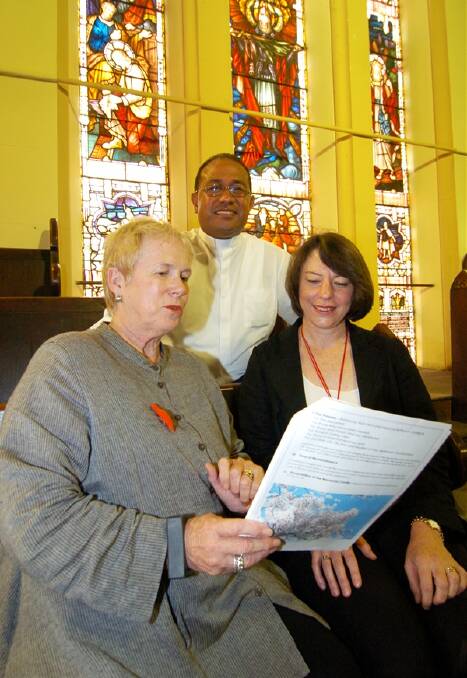 UNITED AS ONE: Councillor Monica Morse, Reverend ‘Oto Faiva and Professor Sharynne McLeod take a final look at the program for tomorrow’s memorial service for the victims of the Japan earthquake and tsunami. Photo: CHRIS SEABROOK 032111zotto1