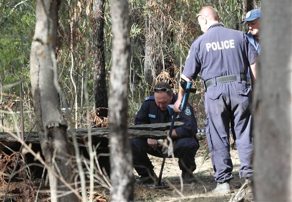GRISLY FIND: Police search for clues near the site where human bones were found last week in Belanglo State Forest.