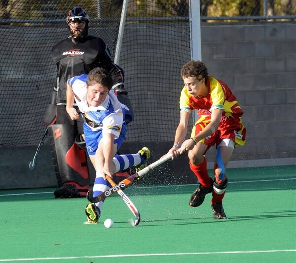 ON THE ROAD: St Pat’s goalkeeper Mick McCabe watches on as his team-mate Josh Toole (left) challenges Bloomfield’s Michael Dillon last Saturday. Today both the Saints’ men’s and women’s Premier League Hockey sides are headed to Parkes. Photo: PHILL MURRAY 052111ppats3