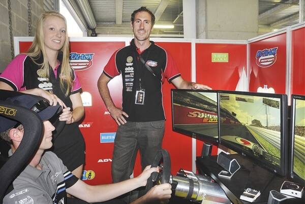 OFF-TRACK FUN: Parkes man Mick Kent tests his ability behind the wheel of the racing simulator as Kate Hazelton and Nik O'Donnell from GWS Motorsport look on. Photo: CHRIS SEABROOK 022612c12hr1