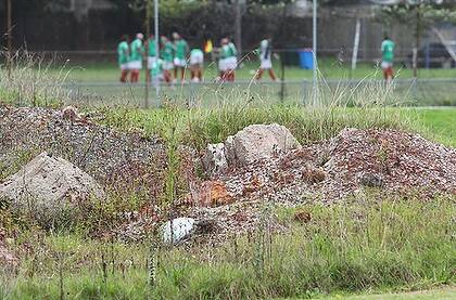 People play in a soccer field near asbestos-contaminated soil which has been dumped illegally.