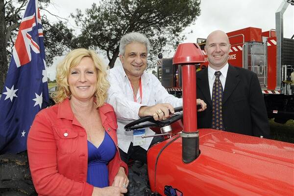 BREKKIE GUESTS: Australia Day ambassador Andy Paschalidis, centre, with his wife Jane and Bathurst mayor Greg Westman on a Fergie tractor at the community breakfast at Eglinton yesterday.  Photo: PHILL MURRAY012612paust1