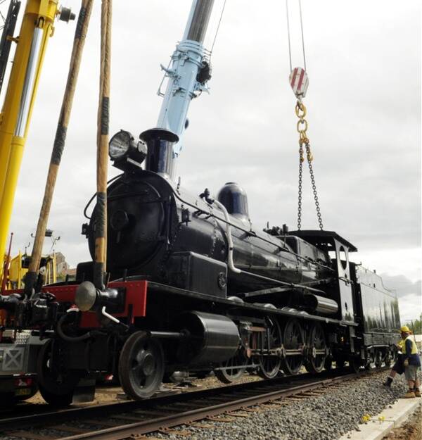 HOMECOMING: Ben Chifley’s D50 class steam locomotive No 5112 is lowered into place at Bathurst railway station yesterday after a restoration journey of more than 20 years. Photo: Phill Murray
