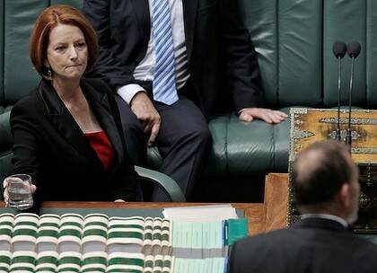 Committed … Julia Gillard listens to Tony Abbott in Parliament yesterday.