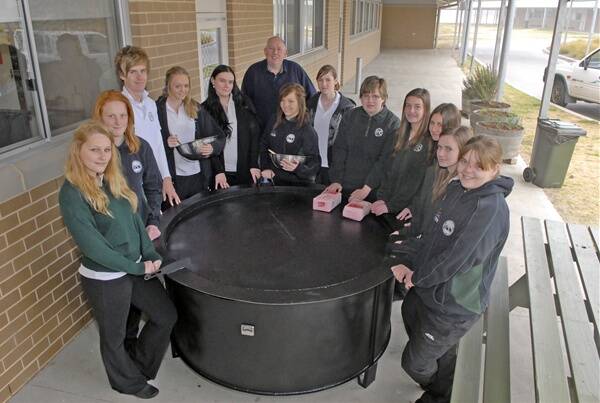 SUPERSIZED CAMP OVEN: Kelso High students preparing to cook the world’s biggest scone include Shannon Reedy, Jessica Daymond, Andrew Christie, Samantha Thompson, Emily Sheridan, Vicki Mitchell, Adelaide Cummings, Karen Drummond, Kelsey Shernan, Amy Guihot, Aleisha Carter and Katie Southwell. They are pictured with industrial arts teacher Craig Miller. Photo: PHILL MURRAY 082411pkelso