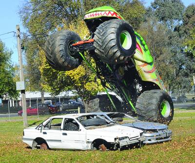 MONSTER MASH: The Raptor Monster Truck about to crunch two cars during a media day at Bathurst Showground.Photo; CHRIS SEABROOK..051210cmonstr1b...