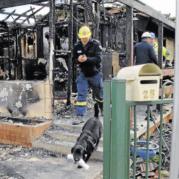 THOROUGH INVESTIGATION: Police dog Winna and his handler Joel Walton from the fire investigation and research unit were yesterday on the scene of Wednesday morning’s Kelso house fire. Four-year-old Billy Johns died in the blaze. Photo:  ZENIO LAPKA091610zfire1