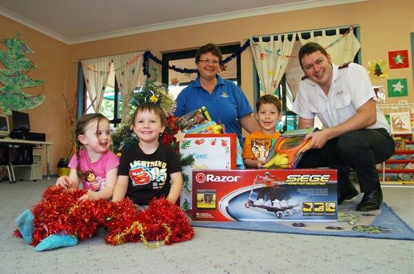 APPEALING: Scarlett and Harry from Keppel Street Kindy watch on with childcare director Trisha Denmead as little Faris hands a gift to Captain Daniel Ross from The Salvation Army in Bathurst. Photo: ZENIO LAPKA 121211ztoys