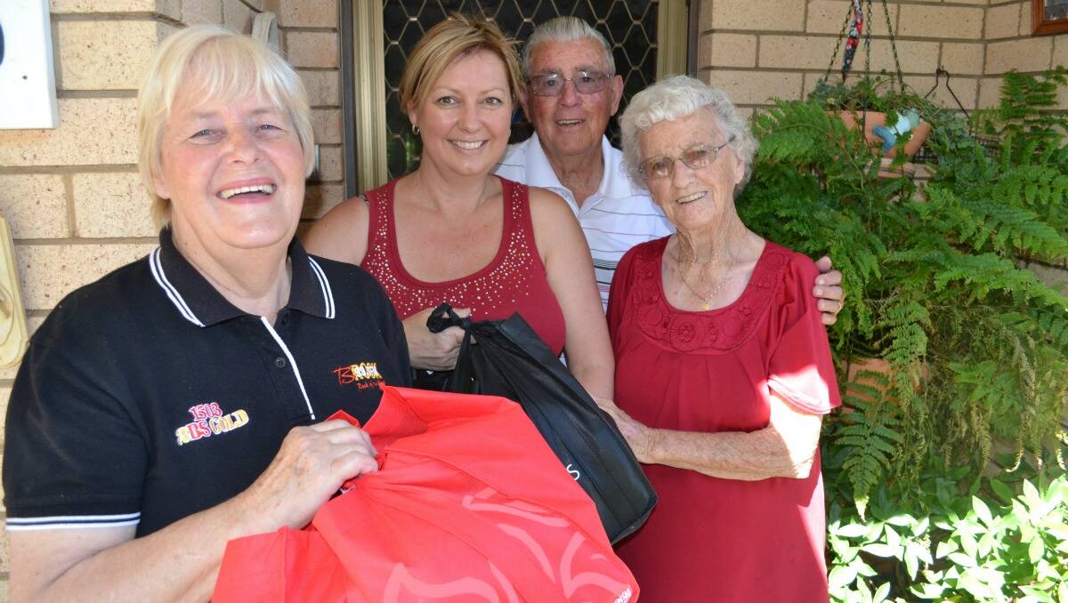 SPREADING FESTIVE CHEER: Noela Sikora and her daughter Susie Morgan hand over a Christmas Miracle hamper to Chifley Village resident Lorna Begley yesterday. Neighbour, Clive Coles joined in the fun. 