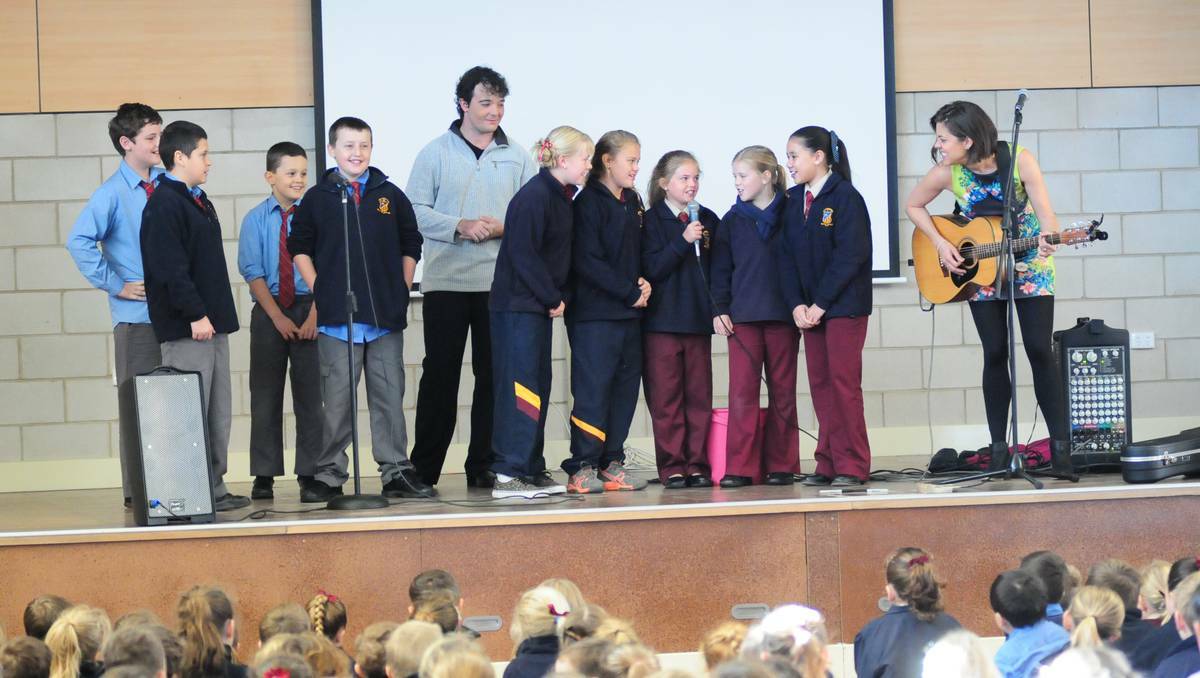 DUBBO: Jason Owen and Amber Lawrence gave St Johns Primary School students a go in front of the microphone during their performance: Matthew Riley, James O’Malley, Ryan Boland, Michael Butler, Gemma Lydford, Laura Egan, Madilyn Burden, Georgia Goodman and Ahlia Amoranto. Photo: LOUISE DONGES