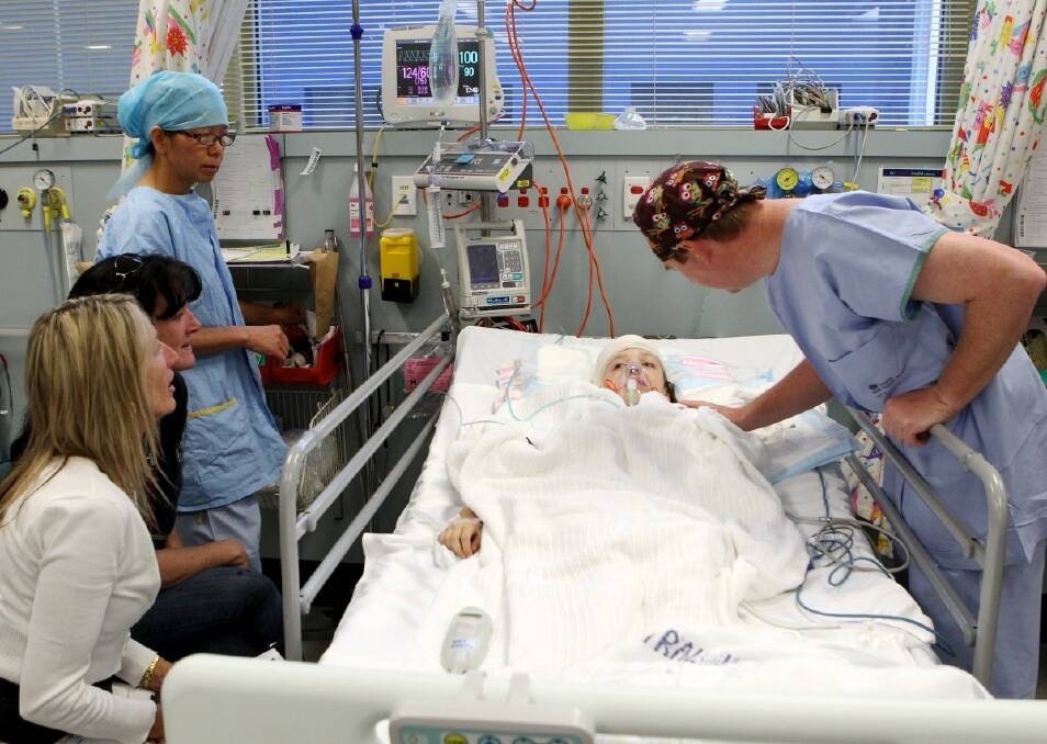 BRAVE BROOKE: Paediatric neurosurgeon Associate Professor Brian Owler checks on Brooke MacKenzie after her brain operation at Westmead Children's Hospital in Sydney. Photo: Janie Barrett