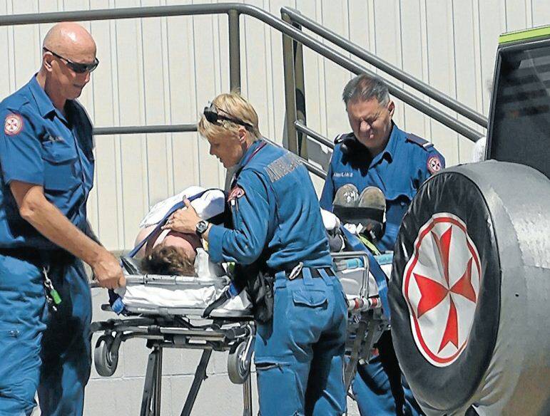 MARCH: Paramedics treating a 17-year-old apprentice plumber at Bathurst Stockland after he fell three metres through a roof. Photo: ANDREW MICALLEF WIDE AREA COMMUNICATIONS 