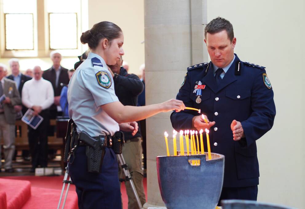 SEPTEMBER: Senior Constable Michaela Stevens and Inspector Mark Wall lighting candles in honour of NSW police officers as part of Police Remembrance Day. Photo: ZENIO LAPKA 092713zprd3