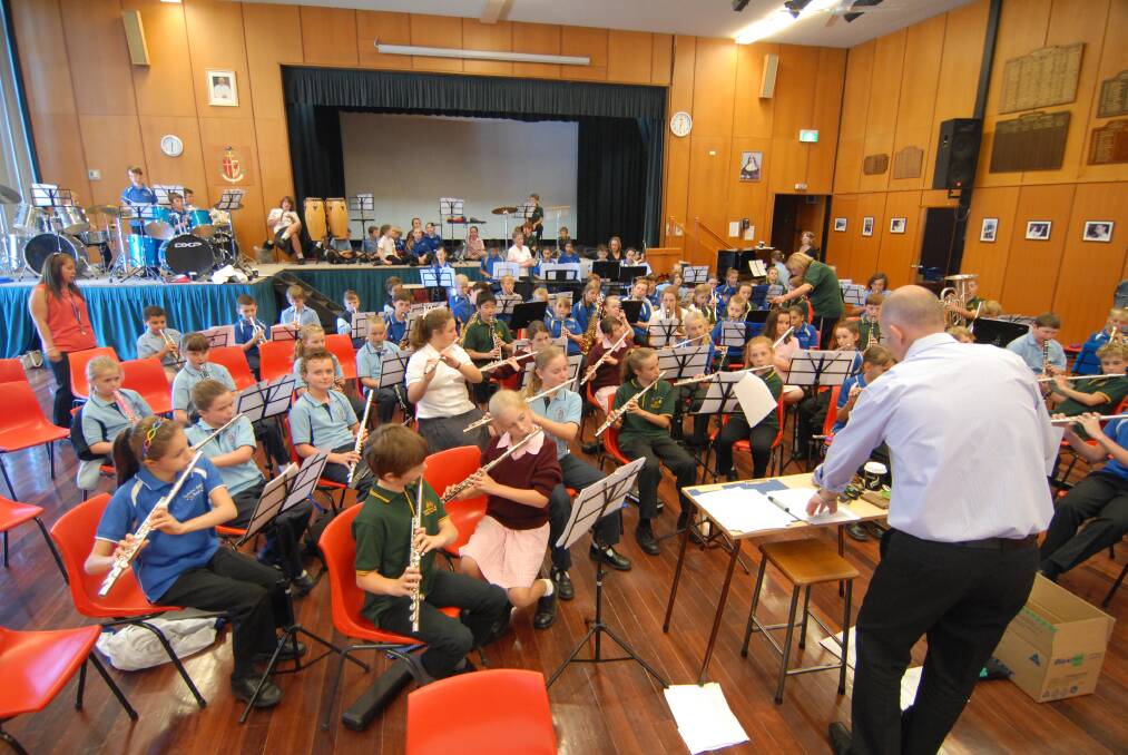 MARCH: Paul Hughes from MacKillop College leads the ensemble at yesterday’s Monster Band Day. Photos: ZENIO LAPKA 032513zband