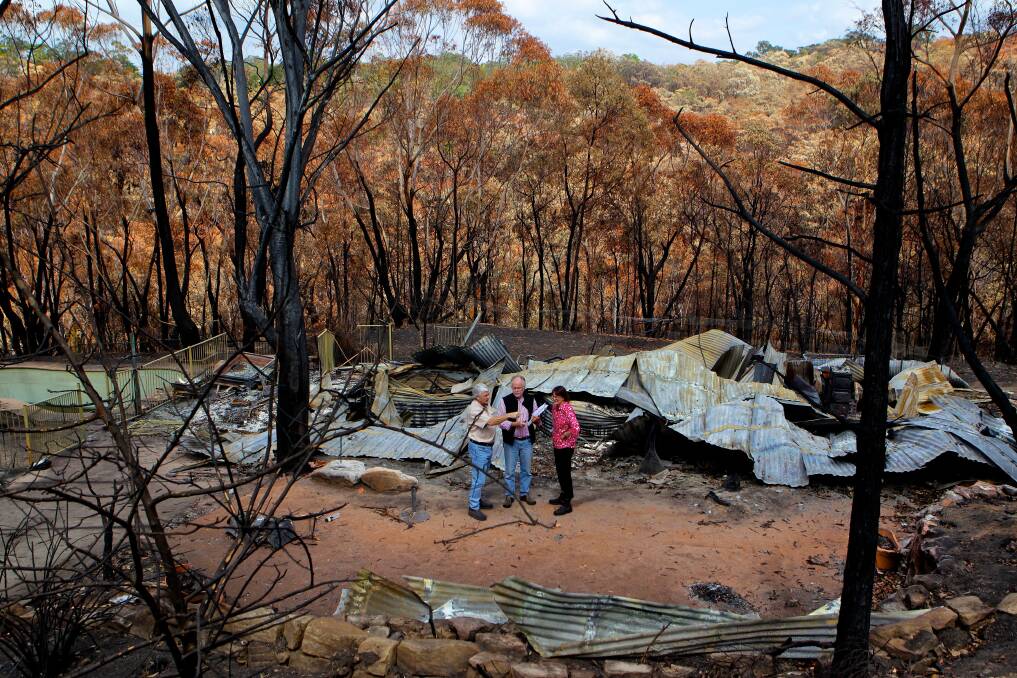 WHAT REMAINS: Nigel Bell, bushfire architect, Ron Fuller (left) and Susan Templeman discuss rebuilding on site of the burnt remains of their home in Winmalee after fire swept through the Blue Mountains suburb.