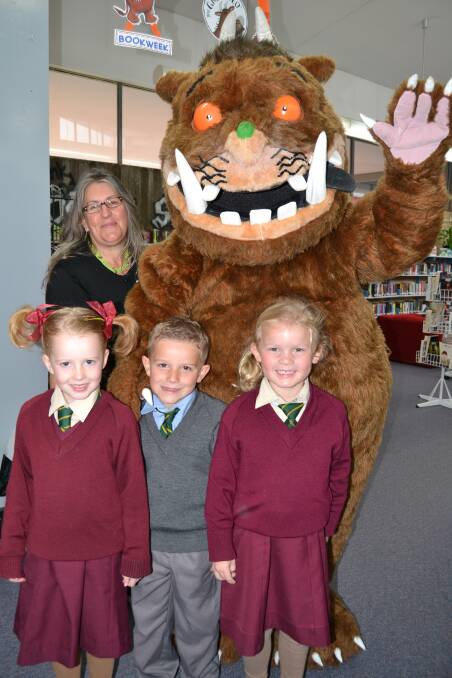 AUGUST: Scout Toole, Logan Coombes and Michaela Bowker, all from Assumption School, with The Gruffalo during yesterday’s Book Week celebrations. 082113jcguff4