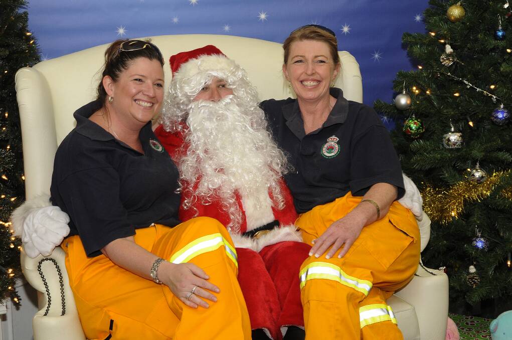 2012: Jannelle Warn and Cordelia Richards from Bathurst Bush Fire Brigade meeting Santa.