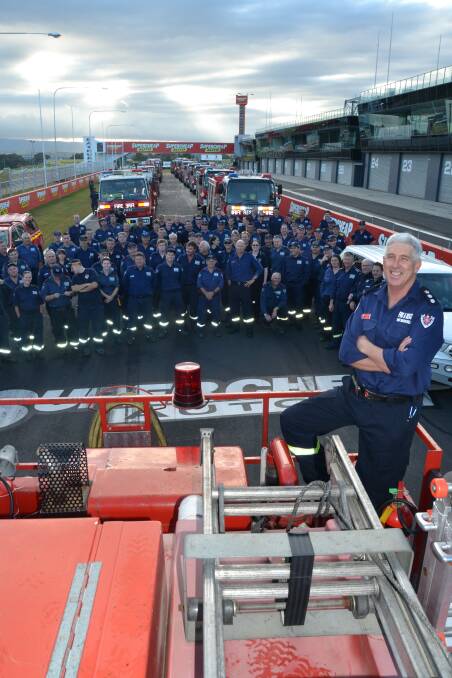 OCTOBER: Chief Superintendant Neil Harris with the 94 firefighters of Region West Strike Team and the 21 fire trucks which lined Pit Straight on the iconic Mount Panorama circuit prior to travelling in convoy to the Blue Mountains to assist with the firefighting effort. Photo: BRIAN WOOD 102313bwfire