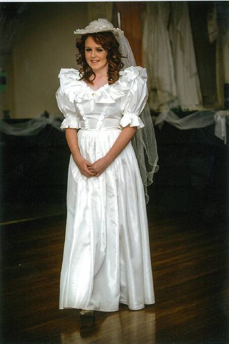 1986: White taffeta dress with a double frill V neckline and a full gathered skirt. A small hat and long veil was worn. The dress was worn by Michelle on her wedding day in Mildura in 1986. The dress was worn by Monique Jones.