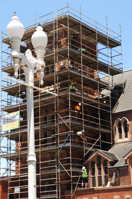 JANUARY: Work continues on the restoration of Bathurst’s St Michael and St John Catholic cathedral. It was noted how the workers passed materials up to the top of the scaffolding by hand – an old-fashioned moving method. Photo: ZENIO LAPKA 010713zchurch1