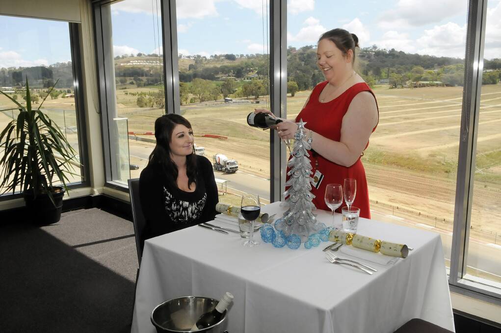 RAISE YOUR GLASSES: Sarah Druce from Rydges Mount Panorama serves Rebecca Hamilton in the hotel function room as she prepares for the Christmas Day rush. Photo: PHILL MURRAY 	121112prydges