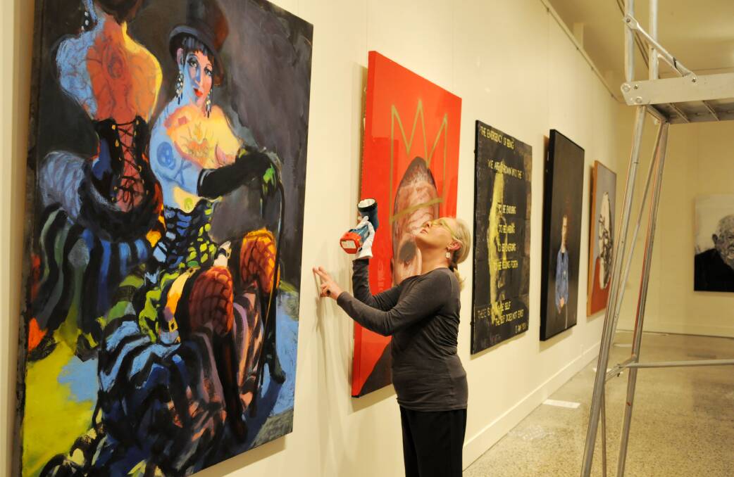 ON DISPLAY: Bathurst Regional Art Gallery acting curator Robina Booth checks a work by Wendy Sharpe (Venus Vamps Burlesque Star) ahead of tonight’s Archibald Prize exhibition opening. Photo: ZENIO LAPKA	 082913zart1