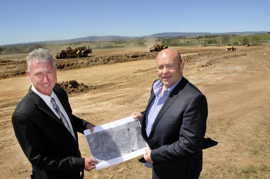 PROGRESS: Bathurst Harness Racing Club CEO Danny Dwyer (left) and president Mark Collins at the site of the new track in October. Now the framework for the stables and grandstand has been erected.