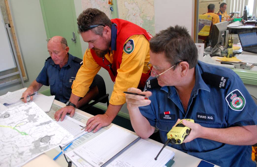 NERVE CENTRE: John Cole, Brett McMillan and Greg Standen were manning the communications room at Evans Rural Fire Service Headquarters Command Centre in Lee Street yesterday. Photo: ZENIO LAPKA 	012014zrfs4