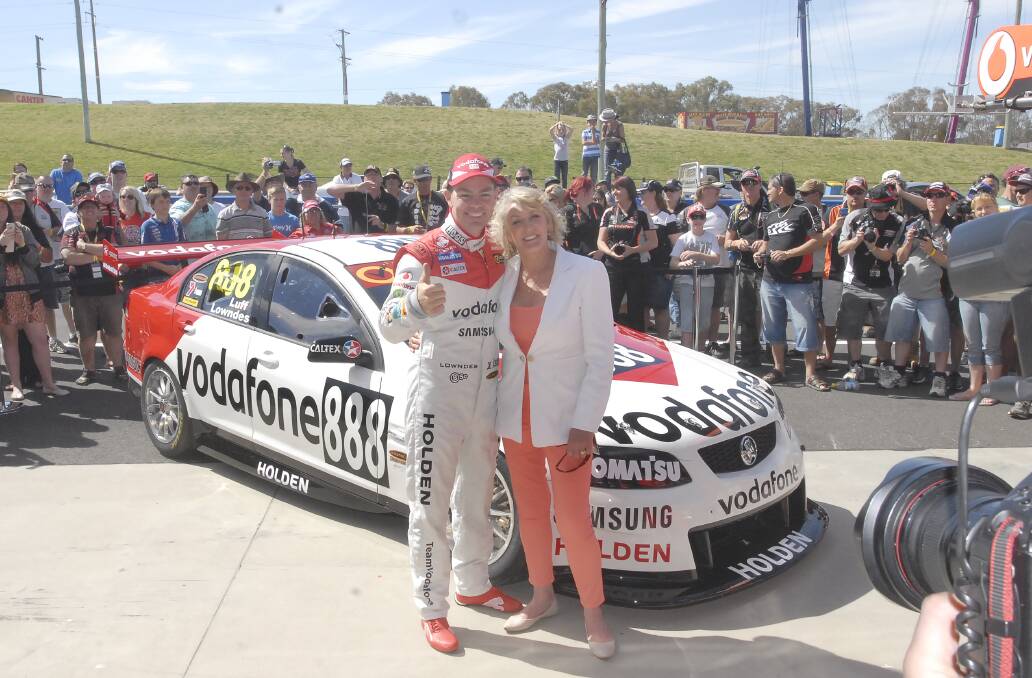 LOOK TO THE PAST: Craig Lowndes and Bev Brock in front of the Team Vodafone Commodore of Lowndes and Warren Luff that has been inspired by Peter Brock’s 1979 Bathurst winning Torana. Photo: CHRIS SEASBROOK 	100312cvoda2