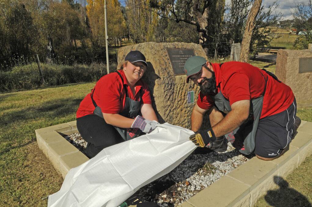 COMMUNITY: Bunnings team members Meg Seaman and Jack Mann spruce up the Cairn War Memorial on the Limekilns Road ahead of tomorrow’s Anzac Day services. Photo: PHILL MURRAY 041813pblitz