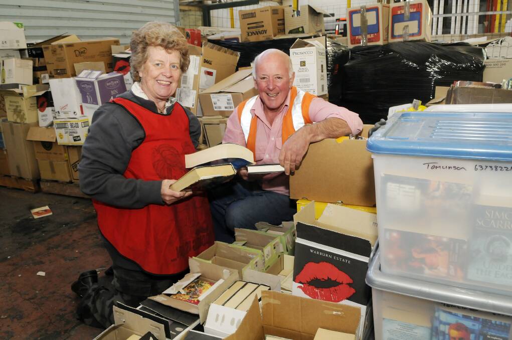 READ ALL ABOUT IT: Volunteer Pam Andersen and Lifeline Central West CEO Alex Ferguson prepare for the Mega Book Fair, which starts today at Bathurst Showground. Photo: PHILL MURRAY 	101513pbooks