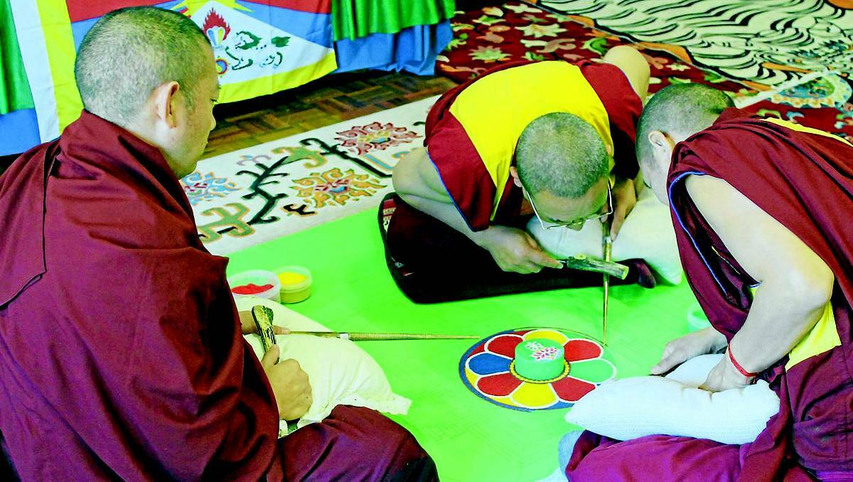 MUDGEE: Buddhist monks from Gyudmed Monastery in South India begin work on a sand mandala at the stables in Mudgee on Tuesday. 