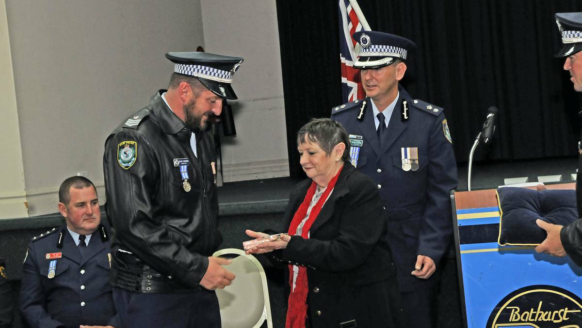 BATHURST: Paul Quin Memorial Award - Sergeant Dave Parsons is presented with his award by the mother of slain police officer Paul Quinn, Barbara Quinn, and Superintendent Michael Robinson. Photo: PHILL MURRAY	052313ppolice1