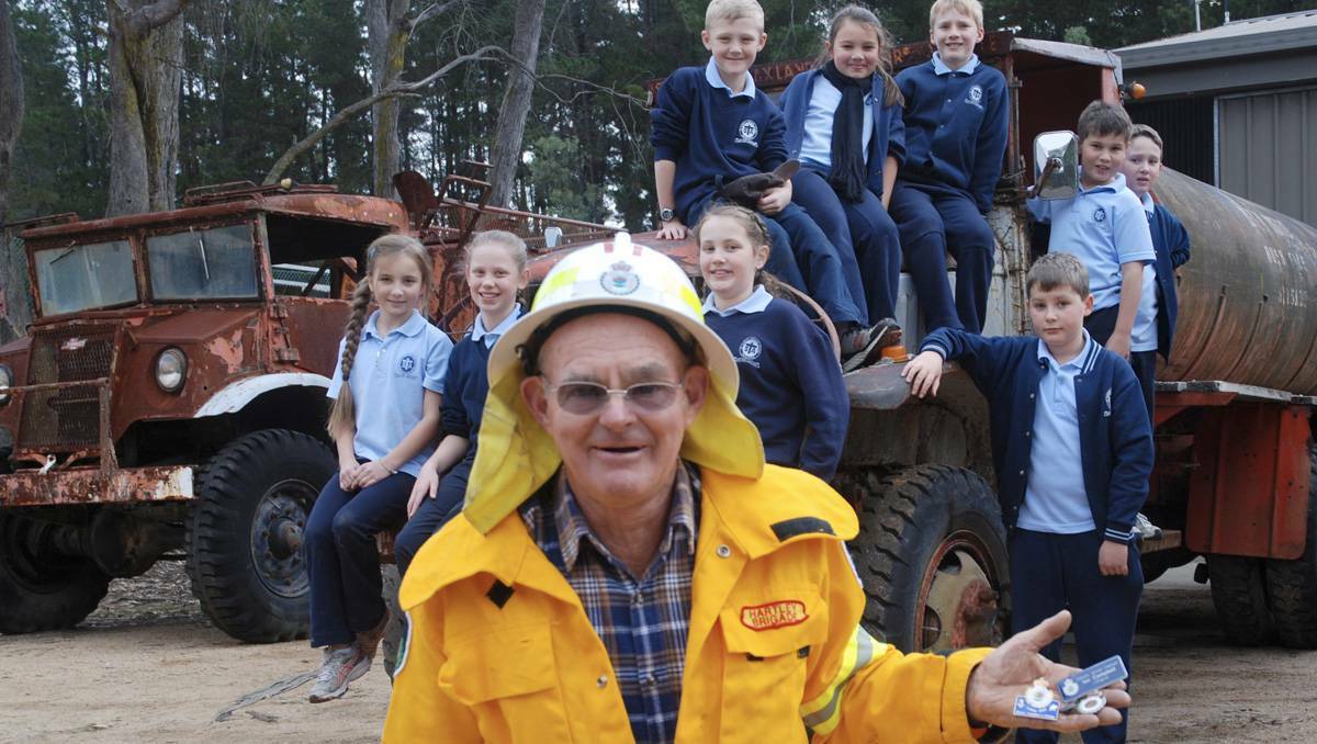 LITHGOW: Ian Campbell will receive an award for 50 years service to the Hartley brigade, an effort that few can match in an organisation acknowledged for its selfless dedication. Ian Campbell is pictured here with students from St Thomas Aquinas Primary School.