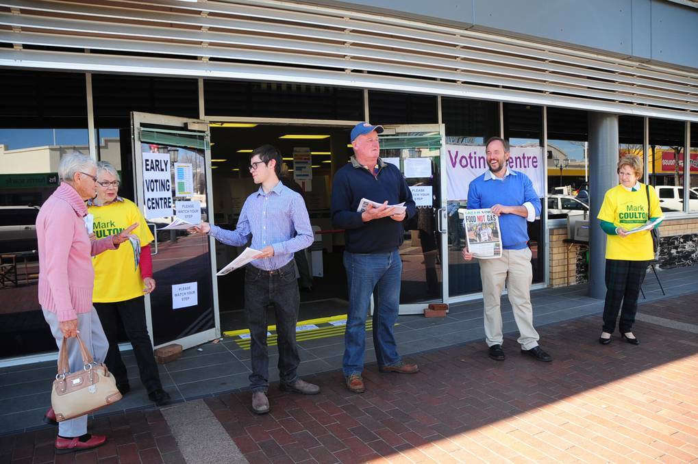 DUBBO: A voter walking through and picking up how-to-vote cards from The Nationals MP supporter Sandra O Brien, ALP candidate Brendan Byron, ALP supporter Ron Adams, The Greens candidate Matt Parmeter and The Nationals supporter Grace Aubusson outside the pre-poll centre. Photo: BELINDA SOOLE