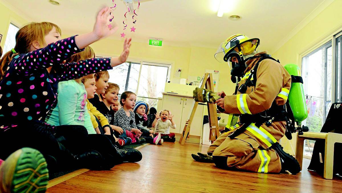 ORANGE: Senior firefighter Tim Collins demonstrates the clothing and equipment firefighters use during a training session at a childcare centre on Wednesday. Photo: STEVE GOSCH 0717sgfire1
