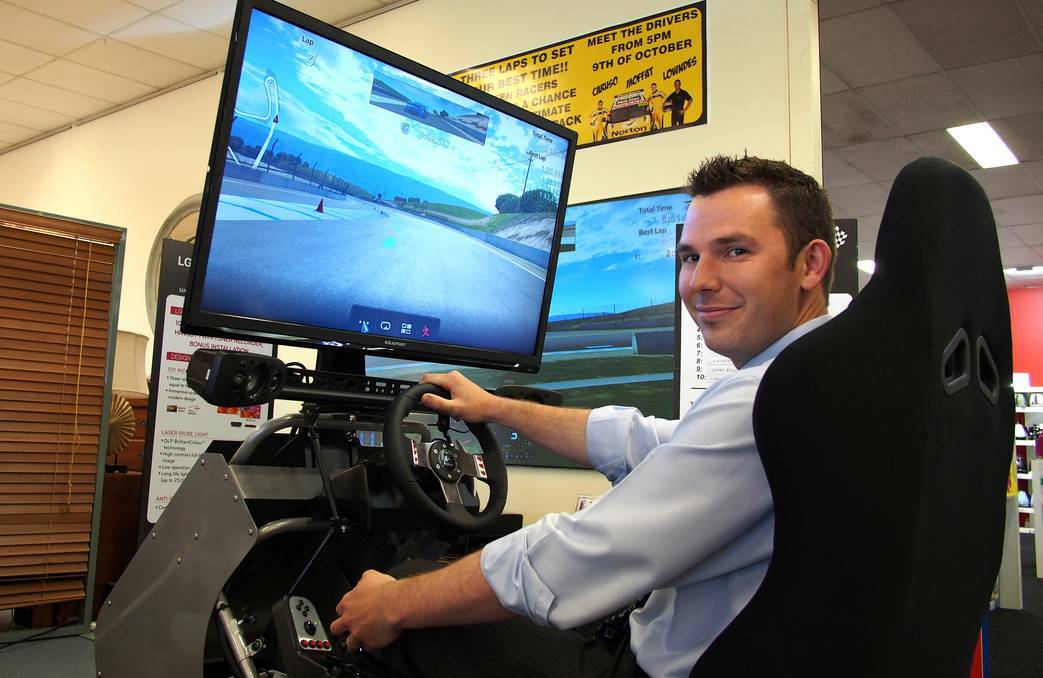 BATHURST: Harvey Norman computers franchisee James Noller tries out the driving simulator which will be running in the lead up to the 2013 Bathurst 1000. Photo: ZENIO LAPKA 091913znorman1