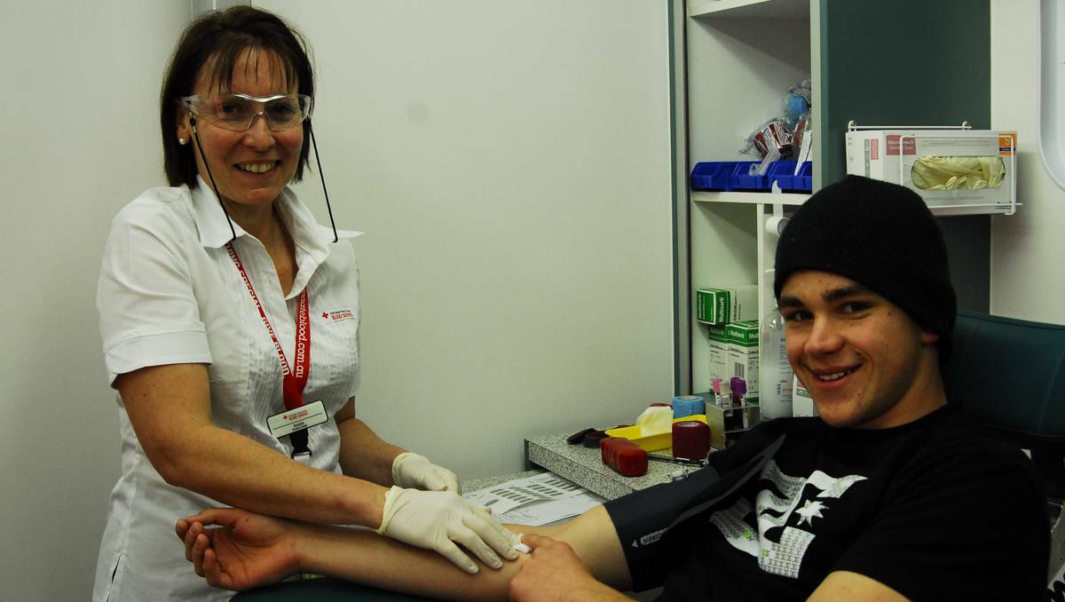 BATHURST:  Paramedic student Nicholas Kilpatrick gives the gift of life as Red Cross Blood Bank’s Rosalie Coelho gratefully accepts the donation. Photo: SARAH STACKMAN	 060313ssblood